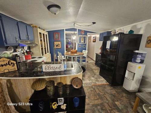 a kitchen with a black refrigerator and a table at Over the hill and through the woods in Ironton