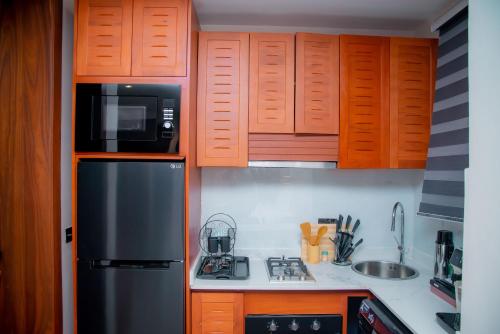 a kitchen with wooden cabinets and a stainless steel refrigerator at Maison Luxe Apartments in Nkunjila