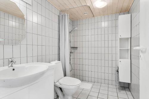 a white bathroom with a toilet and a sink at LK853-Lokken-Norgesvej-2-Lejl-1 in Løkken
