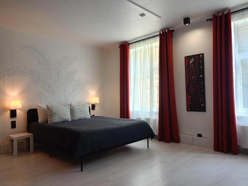 Schlafzimmer mit einem Bett und roten Vorhängen in der Unterkunft Cosy apartment in the heart of Riga in Riga