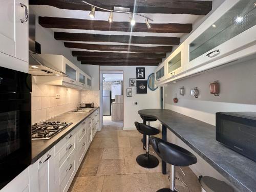 a kitchen with a counter and stools in it at La Floraison in Molesmes