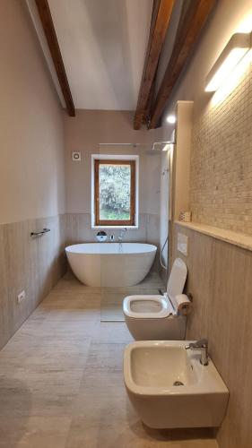 a bathroom with a tub and a toilet and a sink at Villa Piediprato in Spinetoli