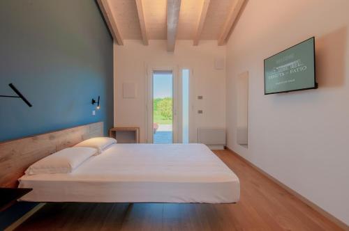 a bedroom with a bed and a tv on the wall at Agriturismo Tenuta del Fatio in Luisago