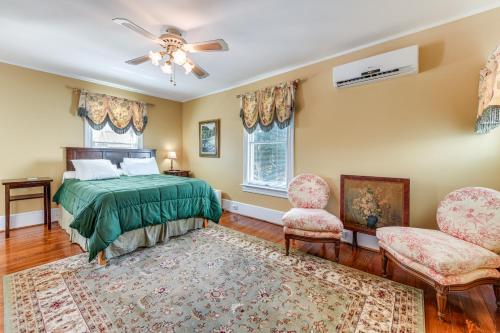 Un dormitorio con una cama y dos sillas. en Historic Waterfront Home with Dock in Reedville!, en Reedville