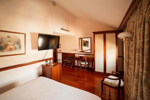 a hotel room with a bed and a television at Phi Hotel Dei Medaglioni in Correggio