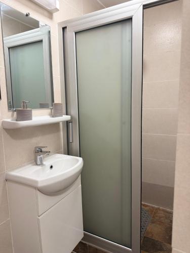a white bathroom with a sink and a shower at Duende in Pointe-Noire
