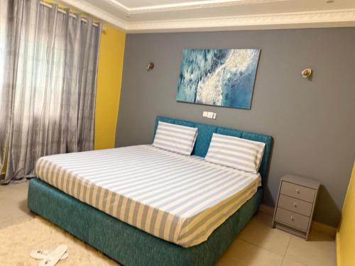 a bedroom with a bed with a blue headboard at Duende in Pointe-Noire