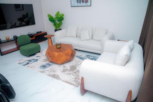 a living room with a white couch and a table at Maison Luxe Apartments in Nkunjila