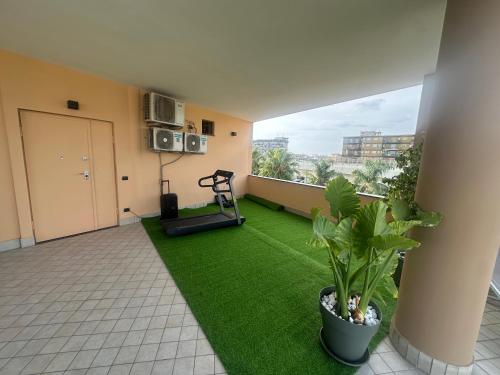a living room with a green rug and a treadmill at Oasi Urbana in Casoria