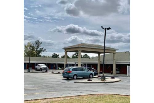 a car dealership with a car parked in a parking lot at Lake Seminole Inn in Sneads