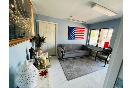 a living room with a couch and an american flag on the wall at Lake Seminole Inn in Sneads
