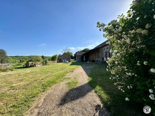 an empty field next to a house with a bush at La Renardière in Chènesaint