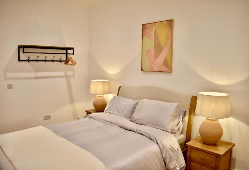 a bedroom with a bed and two lamps on tables at Modern flat in South Yorkshire in Doncaster