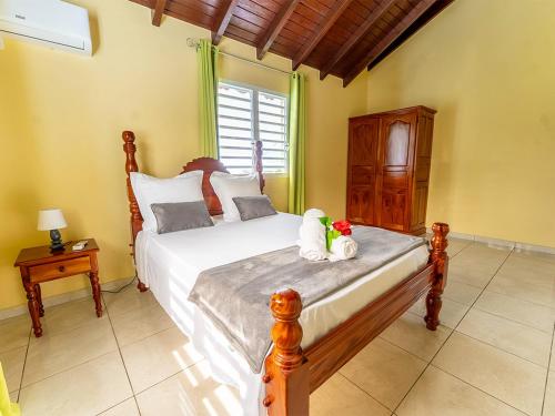 a bedroom with a bed with two stuffed animals on it at Haut de villa Solèy Rivyè- 3 chambres in Petit-Bourg