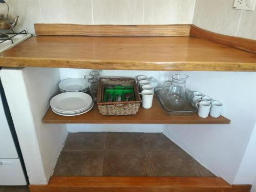 a wooden shelf with plates and dishes on it at Alamos del sur Apart hotel in San Carlos de Bariloche
