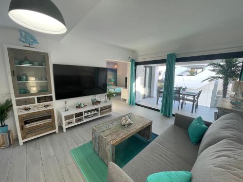 a living room with a couch and a flat screen tv at MarVillaFuerte - Appart Air-Conditioned Swimming Pool & Private Jacuzzi in Villaverde