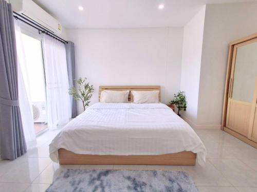 a white bedroom with a large bed with white sheets at Dalbit Thai Stay 2 Bedroom Patong house - 8mins walk to Jungcyelon Bangla Rd in Patong Beach
