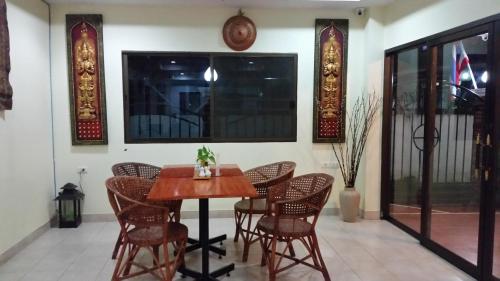- une salle à manger avec une table et des chaises en bois dans l'établissement Villa Oranje Chiang Mai, à Chiang Mai