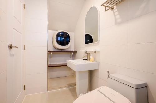 a white bathroom with a sink and a toilet at Hold in Hamdeok with beach in Jeju
