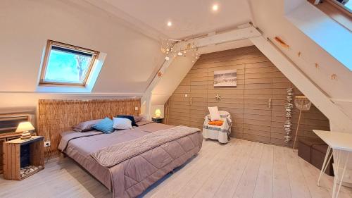 a bedroom with a bed in a room with an attic at Gîte 2 chambres Au Gré du Vent, Côte d'Albâtre, Normandie in Malleville-les-Grès