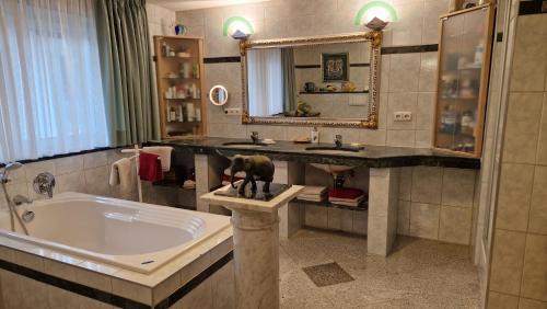 Un baño con bañera, lavabo y espejo. en Alpine Schmiede Chalet, en Ehrwald