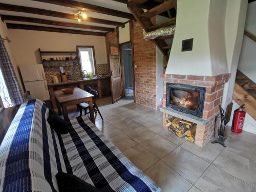 a living room with a brick fireplace and a table at Podołynia in Dwernik