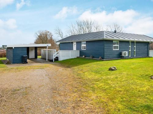 a blue house with a grass yard in front of it at 6 person holiday home in Sydals in Sarup