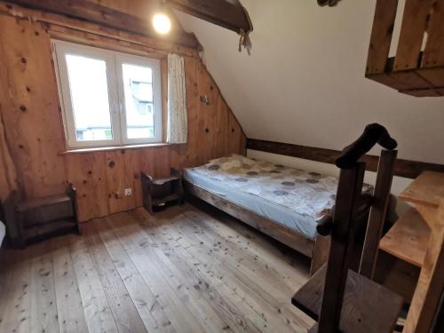 an attic room with a bed and a window at Podołynia in Dwernik