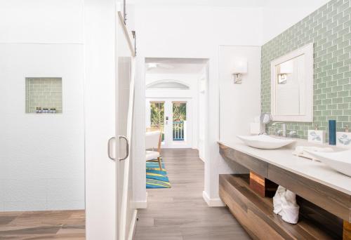 a bathroom with two sinks and green tiles at The Ambergris Grand in San Pedro
