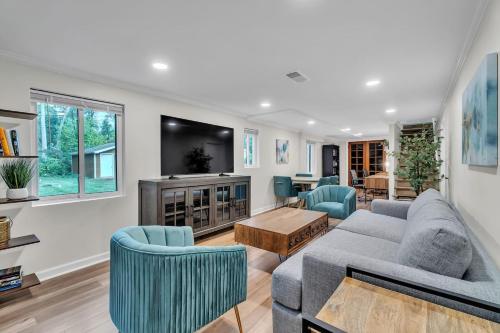 a living room with a couch and chairs and a tv at Serene Suburban Oasis 2 Saunas, Office, Parking in Ann Arbor