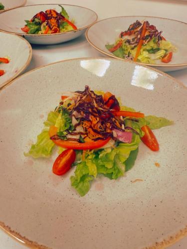 a plate of food with vegetables on a table at The Old Hunting Lodge at The Talbot Inn in Tenbury