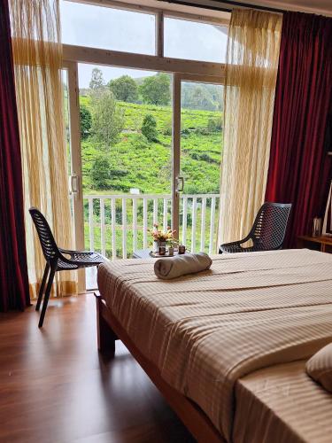 a bedroom with a bed and a large window at Cloud & Mist Inn-Stay with Mountain Views in Kotagiri, Near Ooty in Kotagiri