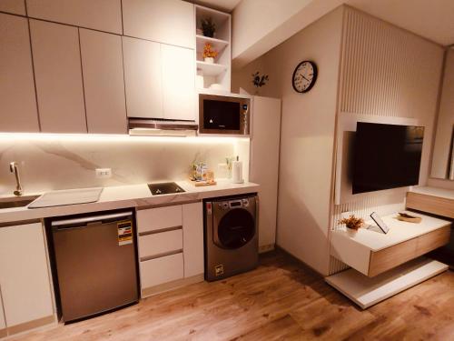a kitchen with white cabinets and a sink and a dishwasher at غرفة فندقية مريحة في قلب التجمع الخامس in Cairo