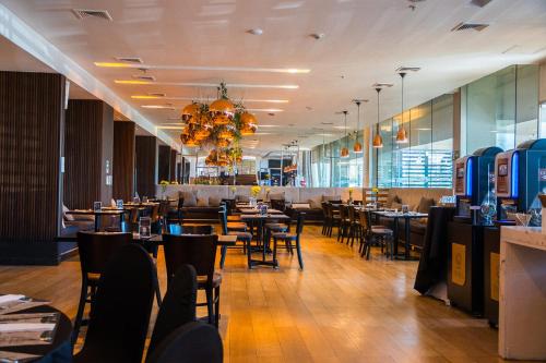 a dining room with tables and chairs in a restaurant at Wyndham Concepcion Pettra in Concepción