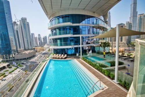 a view of a building with a swimming pool at GYL Holiday Homes -Imperial Avenue - Luxury Retreat Apt with Burj Khalifa Rooftop View - Near Dubai Mall in Dubai