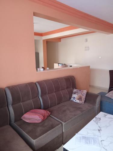 a brown couch in a living room with a mirror at Mtwapa Luxurious Residence with Pool Block 1 in Mombasa
