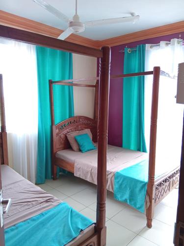 two bunk beds in a room with green curtains at Mtwapa Luxurious Residence with Pool Block 1 in Mombasa