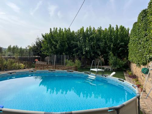 a large swimming pool in a yard with two chairs at Casa Rural Espasa in Espluga de Francolí