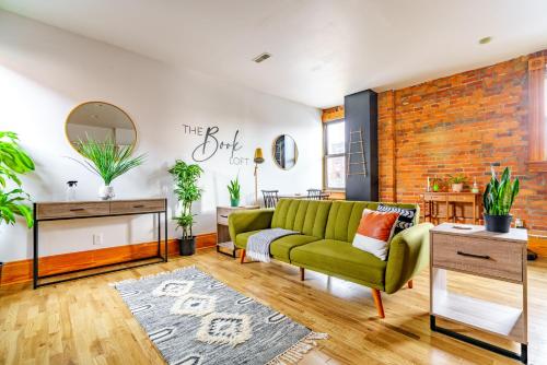 a living room with a green couch and a brick wall at Jungle House Columbus Downtown Free Parking Sleeps 8 - Walk to Convention Center & Nationwide Arena - 1BR Short North Luxury Home - Over 5,800 Five Star Stays in Columbus
