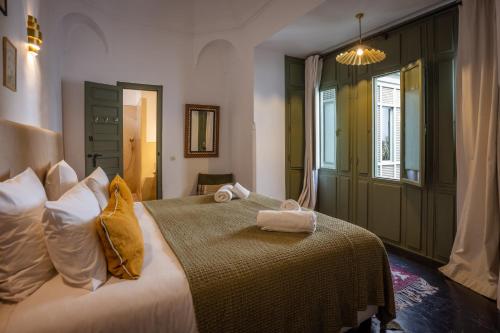Un dormitorio con una cama grande con toallas. en Riad Dar Nakous, en Marrakech