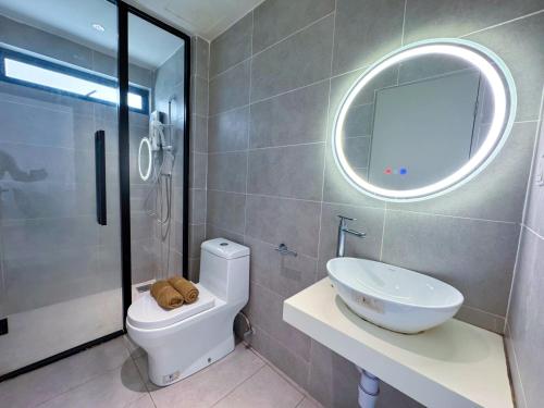 a bathroom with a toilet and a sink and a mirror at DK Impian Damansara Townview Fully Air-Con SUITE in Shah Alam