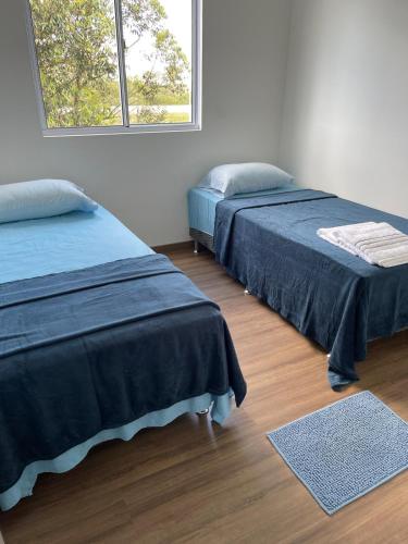 a bedroom with two beds and a window at Apartamento Pelotas in Pelotas