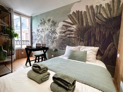 ein Schlafzimmer mit einem großen Bett, auf dem Handtücher liegen in der Unterkunft Le Duplex, parking & Accès Plage ! in Trouville-sur-Mer