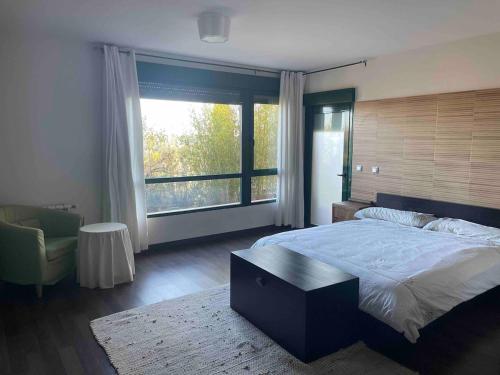 a bedroom with a large bed and a large window at La Casa del Lago in Mesones