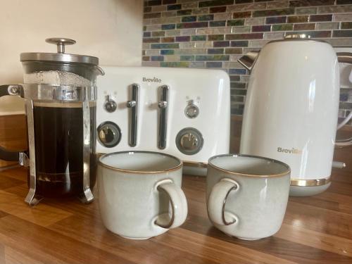a counter with two cups of coffee and a blender at Entire Two Bed Coach House Super King Beds Turn into singles in Countess Wear