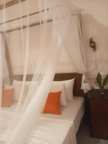 a bedroom with a bed with a canopy at Dishari Tangalle in Tangalle