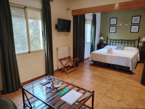a bedroom with a bed and a glass table at Hotel Torre San Juan in San Juan de Alicante