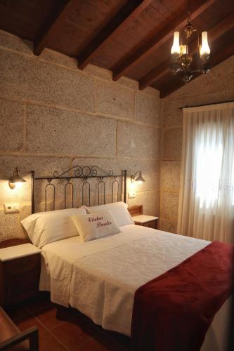 a bedroom with a white bed with a sign on it at Vilaboa Paradise in Villanueva
