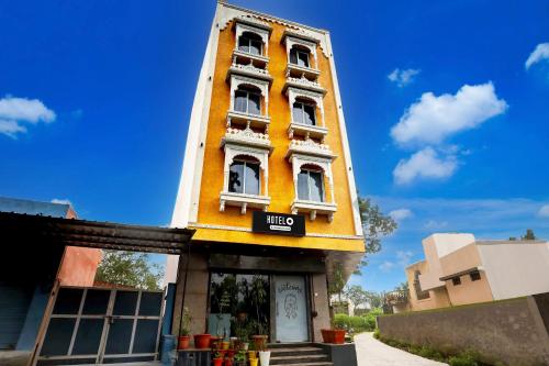 a yellow building with white windows on top of it at Hotel O Shree Palace in Udaipur