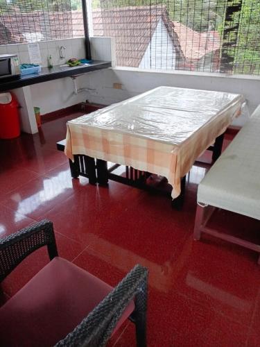 a table with a cover on it in a room at Akkara Homestay in Kottayam